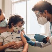 Niño con su madre y un sanitario que va a vacunarle