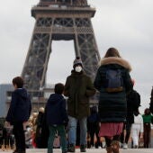 Ciudadanos pasean alrededor de la torre Eiffel de París (Francia)