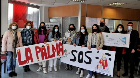 Los alumnos y profesores entregando el cheque solidario
