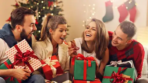 Jóvenes intercambiándose los regalos de Navidad Jóvenes intercambiándose los regalos de Navidad