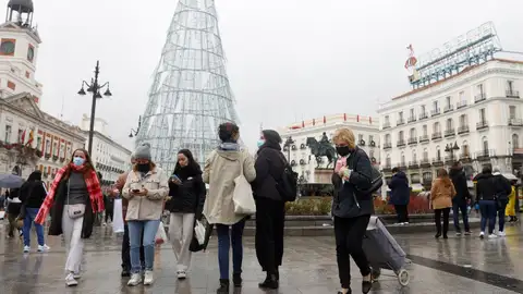 Varias personas caminan con mascarillas por la Puerta del Sol Varias personas caminan con mascarillas por la Puerta del Sol