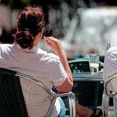 Una mujer fumando en una terraza Una mujer fumando en una terraza