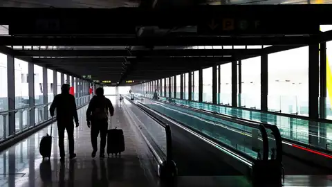 Dos pasajeros cruzan una de las terminales del Aeropuerto Adolfo Suárez Madrid-Barajas, en una imagen de archivo. Dos pasajeros cruzan una de las terminales del Aeropuerto Adolfo Suárez Madrid-Barajas, en una imagen de archivo.