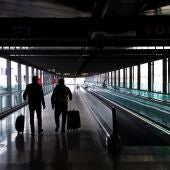 Dos pasajeros cruzan una de las terminales del Aeropuerto Adolfo Suárez Madrid-Barajas, en una imagen de archivo.
