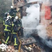 Bomberos sofocando llamas en el incendio que costó la vida a una mujer en Piloña