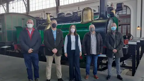 Los asistentes a la reunión junto a una maquina de vapor antigua Los asistentes a la reunión junto a una maquina de vapor antigua