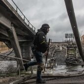 Militares ucranianos pasan junto a un puente destruido en la ciudad de Irpin, en la provincia de Kiev. / Efe