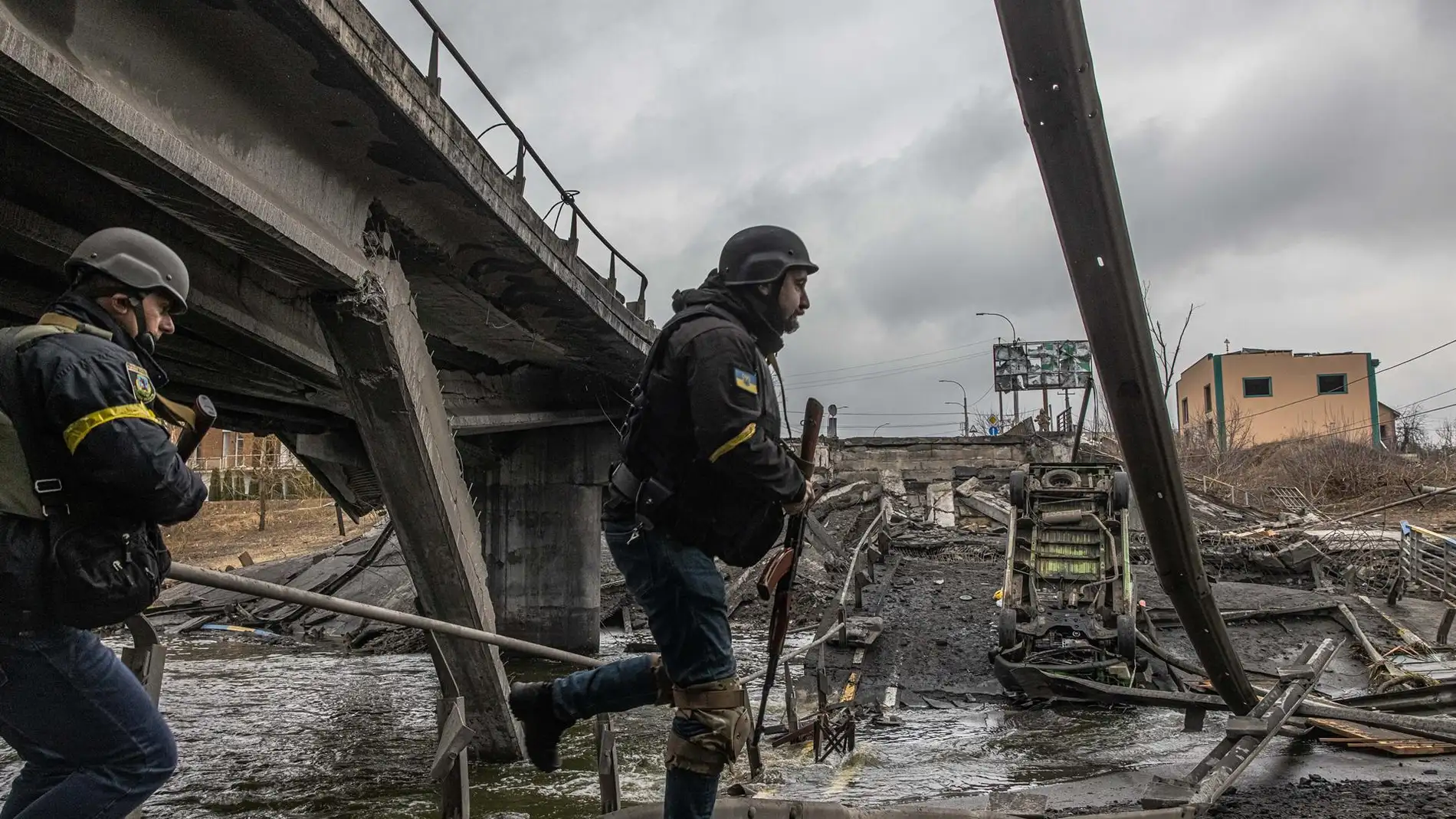 Militares ucranianos pasan junto a un puente destruido en la ciudad de Irpin, en la provincia de Kiev. / Efe