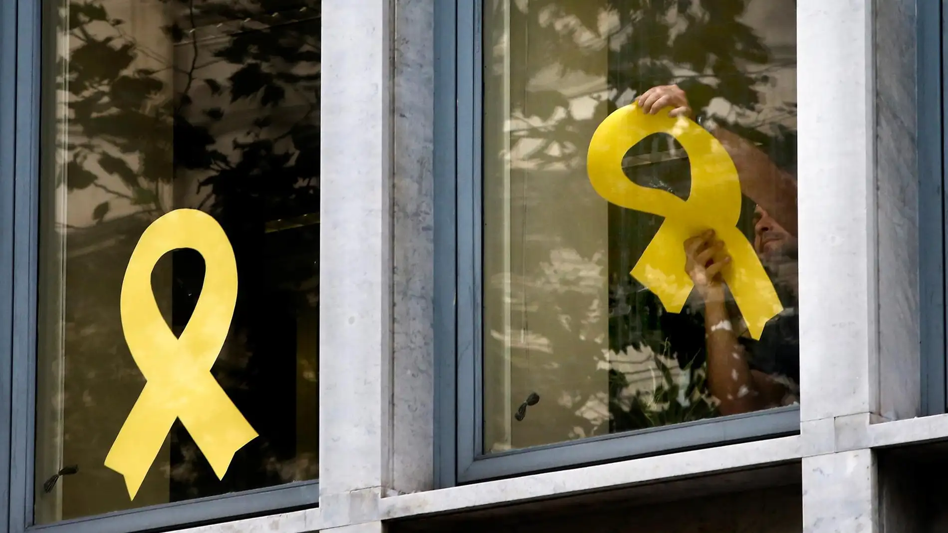 Lazos amarillos en los ventanales de una oficina de Barcelona. / Efe