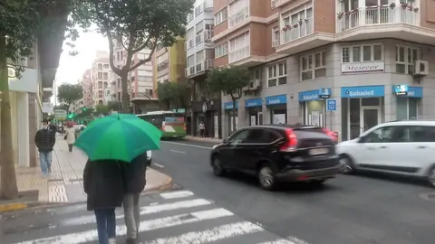 Ciudadanos caminan con paraguas en una calle de Elche. Ciudadanos caminan con paraguas en una calle de Elche.