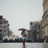Una mujer pasea con un paraguas en Madrid.