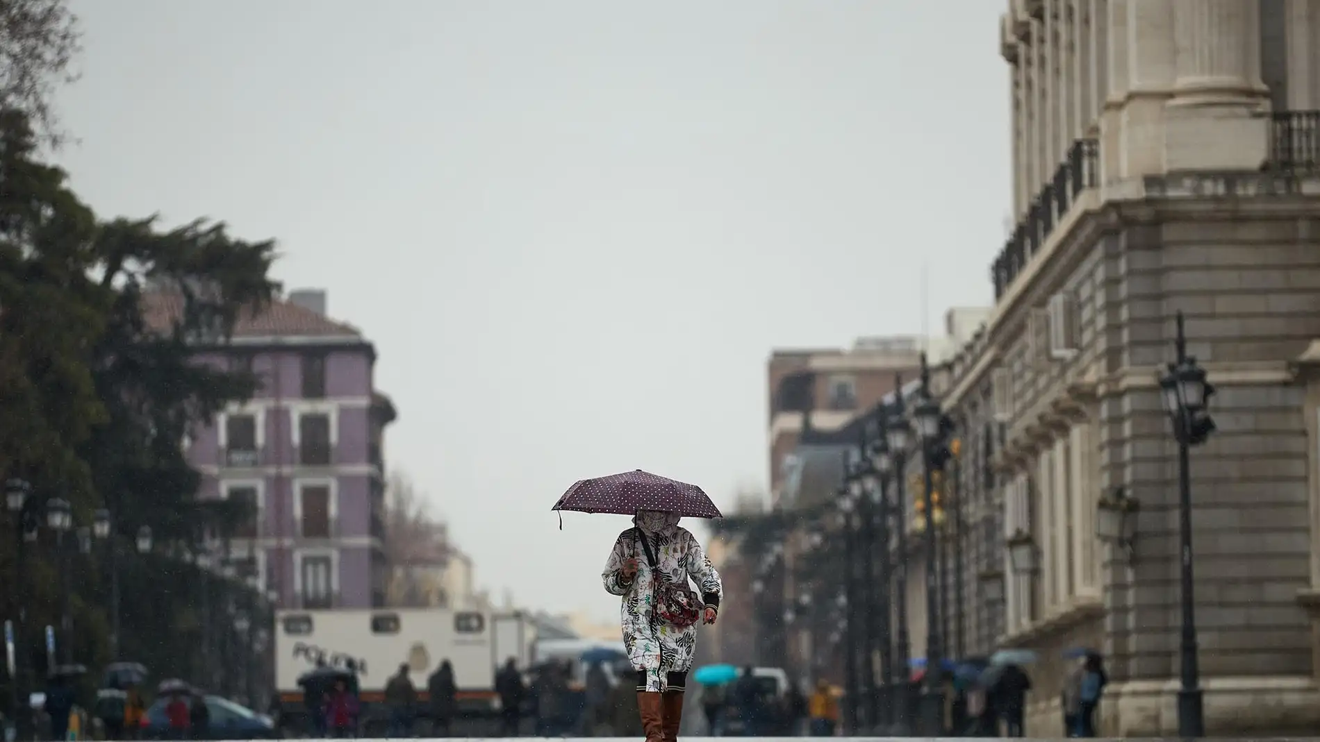Una mujer pasea con un paraguas en Madrid. / Efe