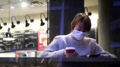 Una mujer con la mascarilla puesta en el interior de un local. 