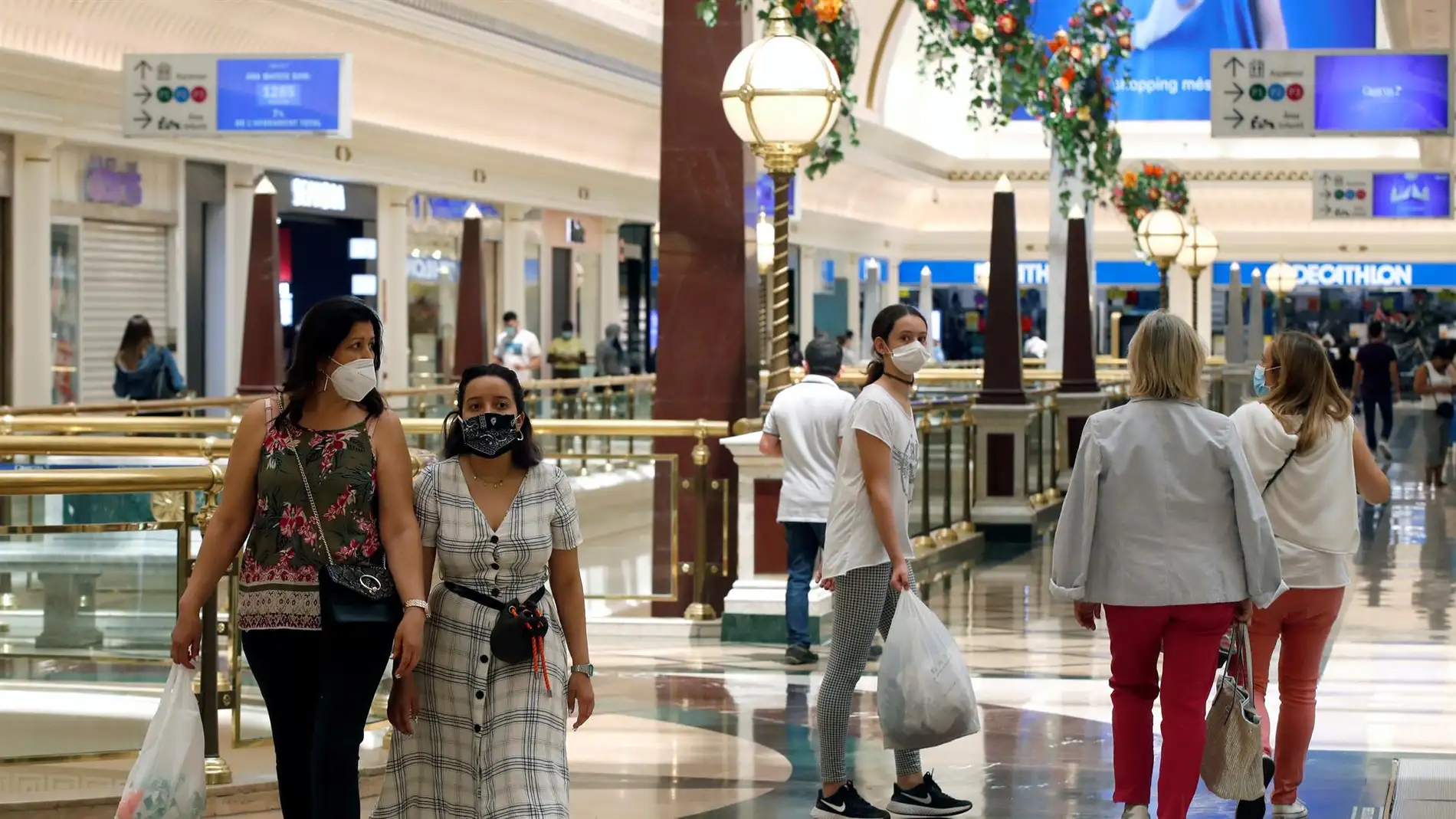 Personas con mascarillas en un centro comercial | Foto: EFE/Toni Albir