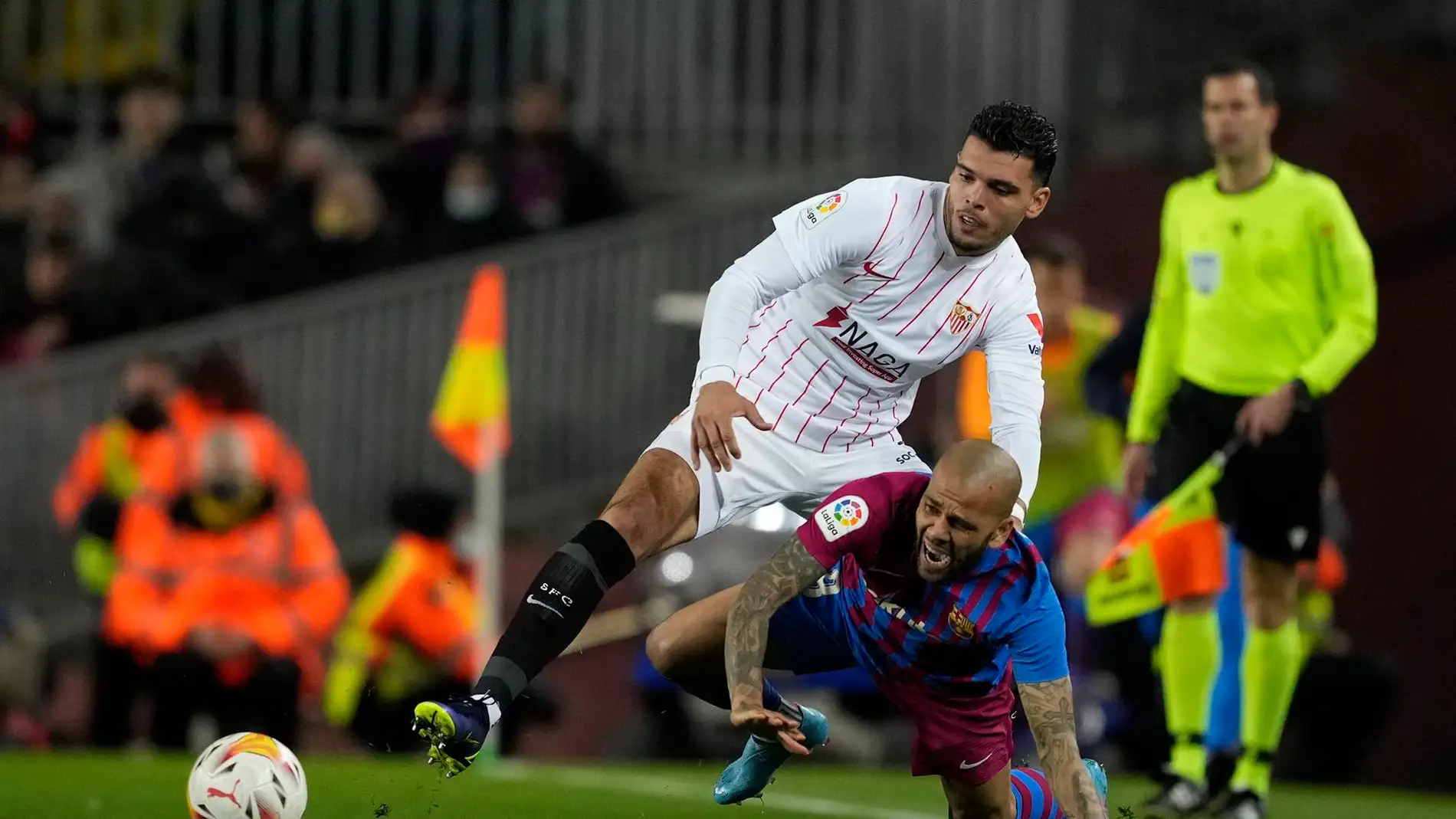 El defensa brasileño del FC Barcelona, Dani Alves, cae ante el defensa neerlandés del Sevilla, Karim Rekik, durante el encuentro correspondiente a la jornada 30 de primera división disputado en el estadio del Camp Nou de Barcelona.
