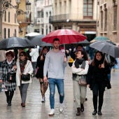 Varias personas pasean bajo la lluvia, en una foto de archivo