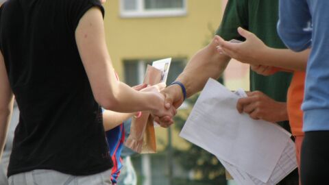 Dos personas salud&aacute;ndose con la mano