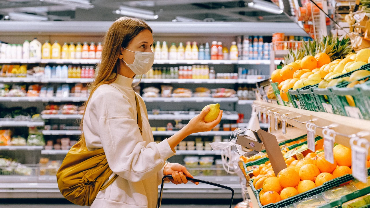 Una mujer comprando con mascarilla en un supermercado