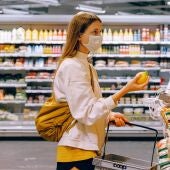 Una mujer comprando con mascarilla en un supermercado