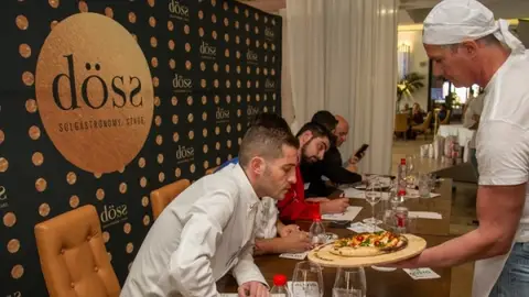 Un miembro del jurado observa atentamente el plato de uno de los cocineros participantes Un miembro del jurado observa atentamente el plato de uno de los cocineros participantes