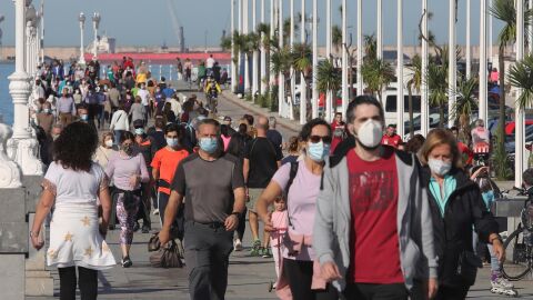 Varias personas pasean con mascarillas. / Efe