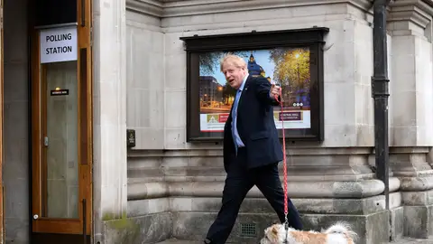 El primer ministro británico, Boris Johnson, llega a un colegio electoral con su perro Dilyn para votar durante las elecciones locales en Westminster, Londres