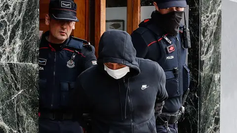 Agentes de la Ertzaintza trasladan al detenido por su presunta vinculación con los asesinatos de hombres en Bilbao tras registrar un piso en la localidad guipuzcoana de Irun