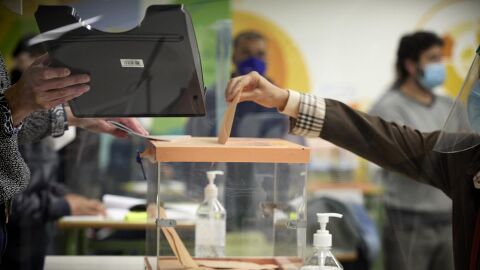 Una mujer vota en una mesa electoral