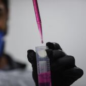 Una persona analizando una muestra en un laboratorio