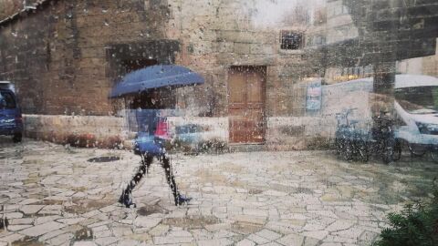 Una mujer pasea bajo la lluvia en Palma Una mujer pasea bajo la lluvia en Palma