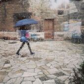 Una mujer pasea bajo la lluvia en Palma
