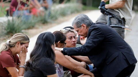 Un arzobispo habla con familiares tras el tiroteo en Uvalde (Texas).