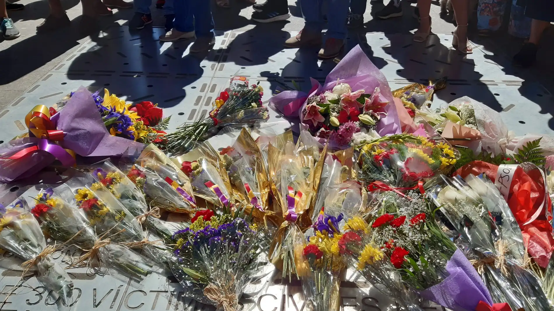 Ofrenda de flores sobre la lápida que recuerda a los fallecidos en el bombardeo