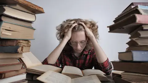 Una persona lee libros. Cómo hacer frente a la ansiedad durante la Selectividad