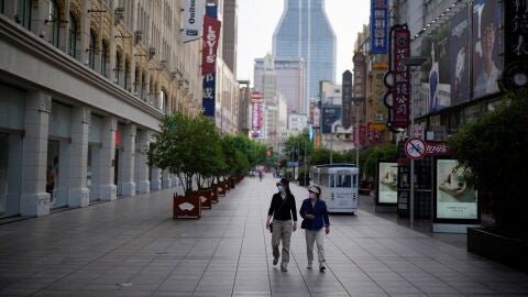 Dos personan caminan por las calles de Shanghai.