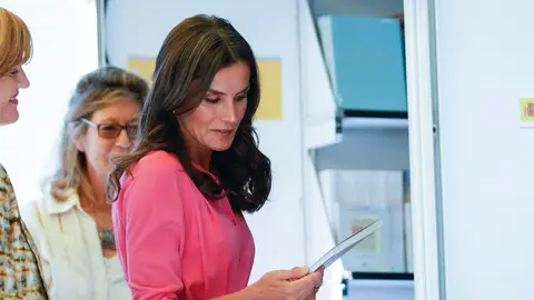 La reina Letizia ojea un ejemplar en una de las casetas mientras inaugura este viernes la 81 edición de la Feria del Libro de Madrid en el parque del Retiro/ EFE/Javier Lizón