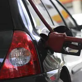 Un vehículo recarga carburante en gasolinera Un vehículo recarga carburante en gasolinera
