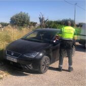 Un agente de la Guardia Civil junto al vehículo implicado en la denuncia.