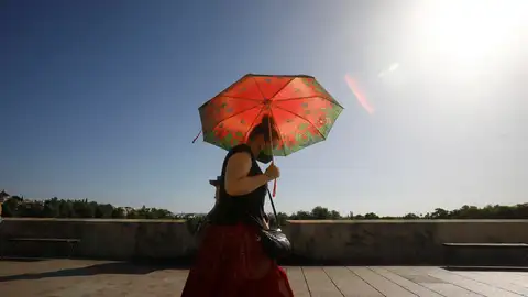Una persona se protege del calor con un paraguas.