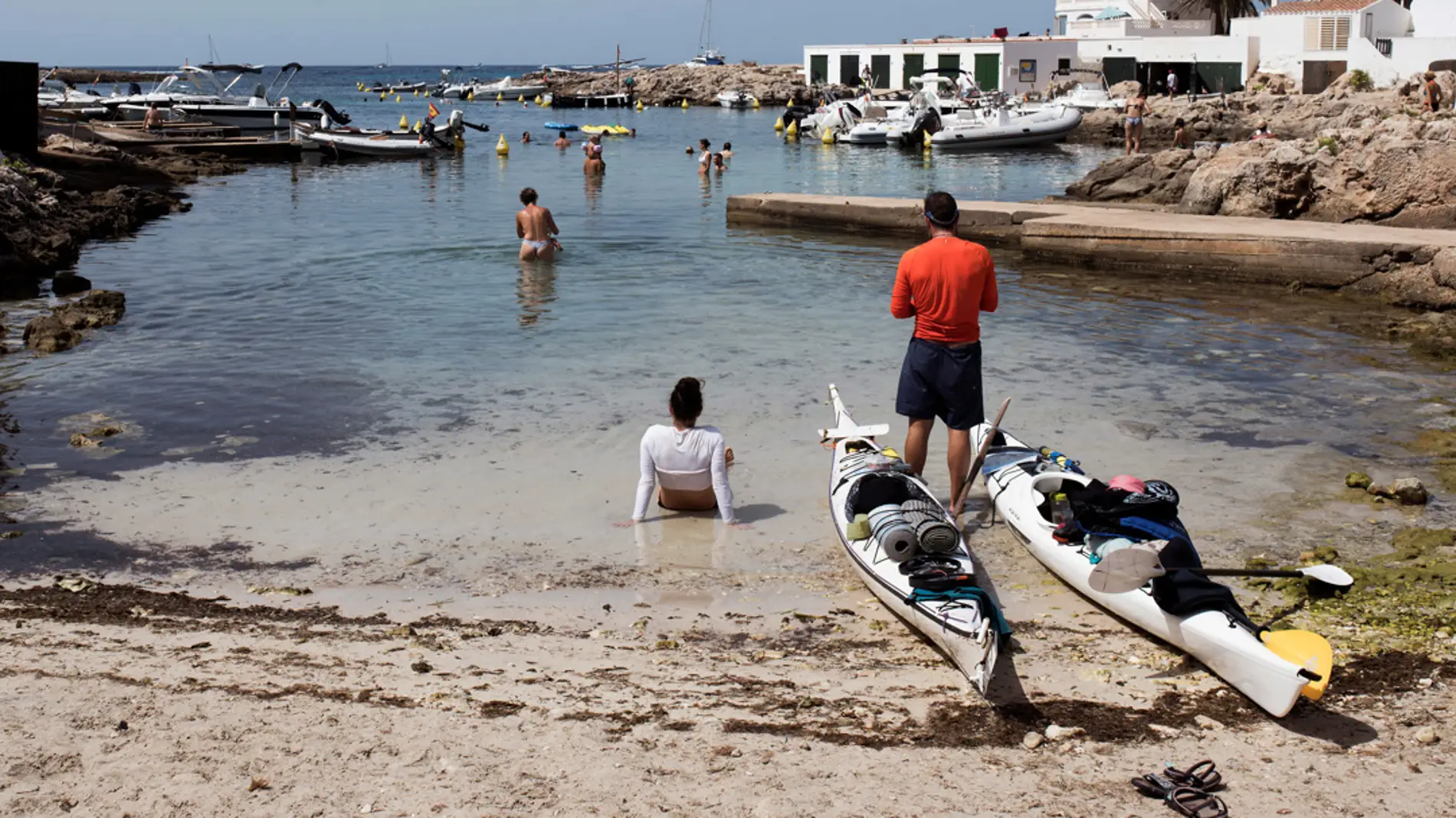 En la imagen de archivo, bañistas y pescadores buscan lugares para refrescarse entre las rocas y pequeñas calas del litoral de Sant Lluís, Menorca/ EFE/David Arquimbau Sintes