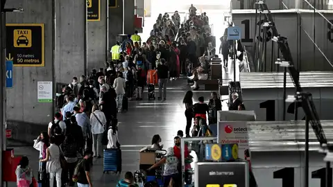 Decenas de personas hacen cola para facturar el equipaje en el Aeropuerto de Barajas de Madrid