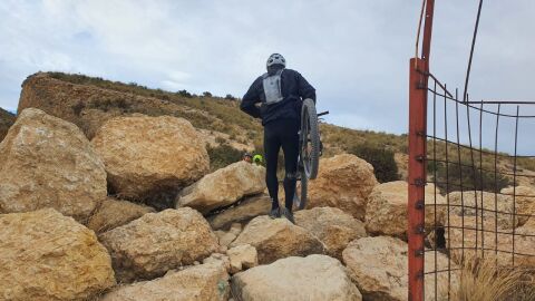 Ciclista en un camino rural de Elche cubierto de piedras. Ciclista en un camino rural de Elche cubierto de piedras.
