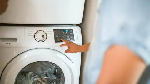 Una persona poniendo la lavadora
