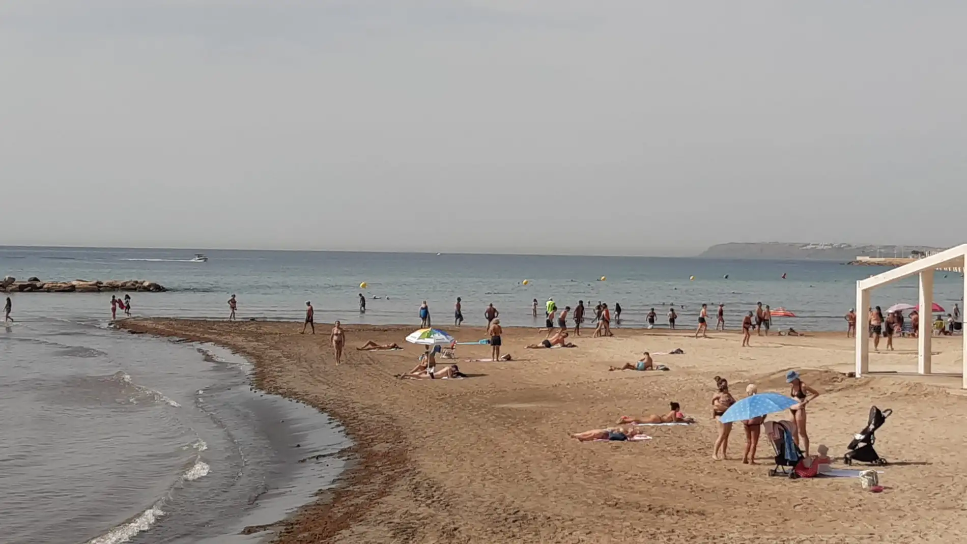 Bañistas combaten el calor esta mañana en la playa de Cocó