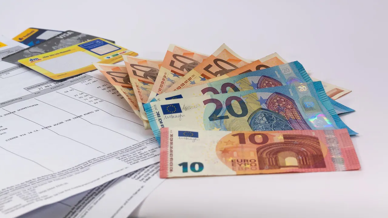 Imagen de archivo de unos billetes de euro, unas tarjetas de crédito y unas facturas