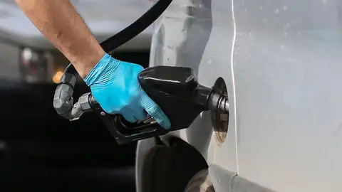 Un hombre echando gasolina en su coche