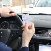 Una persona sujeta su carné de conducir en la mano derecha en una foto de archivo