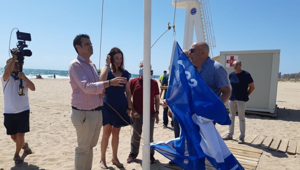 Carles Molina, concejala de Turismo de Elche, iza la bandera azul en la playa de El Altet.