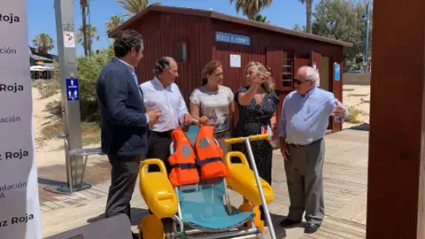 Ayuntamiento, Cruz Roja y AXA presentan el servicio de baño adaptado e la playa de La Barrosa
