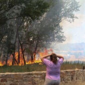 Una mujer observa las llamas del incendio forestal registrado en la comarca de Tábara (Zamora)